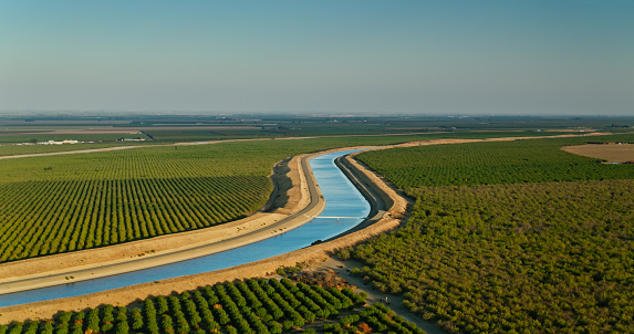 Aerial shot of farmland and aqueduct just off interstate 5 in Stanislaus County, California on a sunny afternoon in autumn.