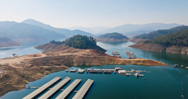 Aerial Shot of Boats Moored on Drought Stricken Lake Shasta in California Aerial shot of Lake Shasta in Northern California on a sunny day in early Fall. Lake Shasta is a reservoir on the Sacramento River created by the construction of Shasta Dam. At the time of shooting the lake was at 33% capacity, or 58% of its historical average for the time of year, a symptom of the ongoing megadrought. marina california stock pictures, royalty-free photos & images