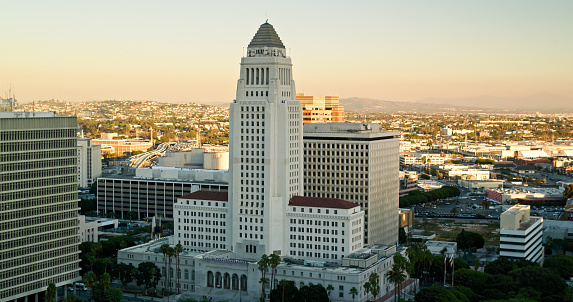 Aerial establishing shot of City Hall and other government buildings in the Civic Center of Downtown Los Angeles (DTLA) at sunset.