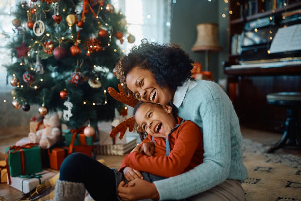 allegra madre e figlia afroamericana che si divertono il giorno di natale a casa. - christmas family child christmas tree foto e immagini stock