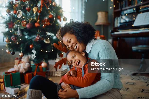 Cheerful African American Mother And Daughter Having Fun On Christmas Day At Home Stock Photo - Download Image Now