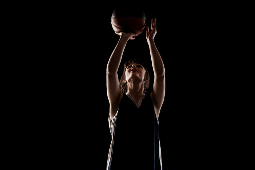 Friendly basketball player holding a ball and looking at the camera - sports concepts