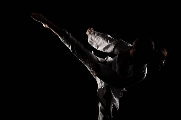 istock Young girl exercising karate. Child in kimono against black background. 1437378564