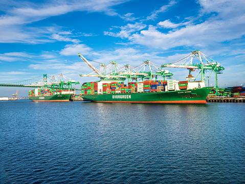 Los Angeles, CA, USA - November 17, 2017: Two Evergreen container ships -- Ever Lunar and Ever Shine -- load cargo at the Everport terminal, one of 25 terminals along the 43 miles of waterfront at the Port of Los Angeles.