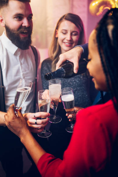 istock People hands holding flute glasses while pouring champagne 1437386113
