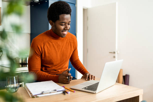 istock Smiling African American man using laptop 1437387827
