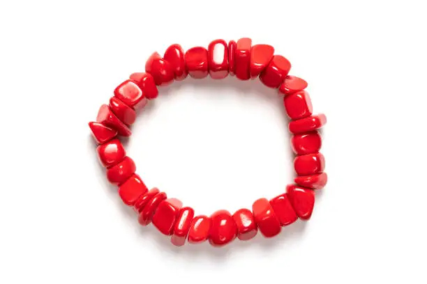 Red bead bracelet isolated on white. Stones accessory. Rosary, prayer beads top view. Handmade concept