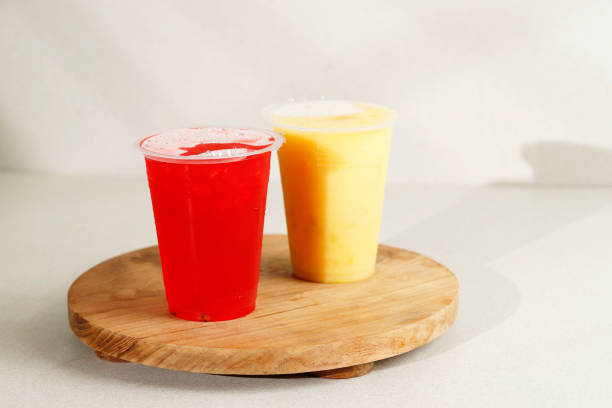 istock Red Water Melon and Mango Juice on Wooden Board, Served with Sealed Plastic Cup. 1437395469