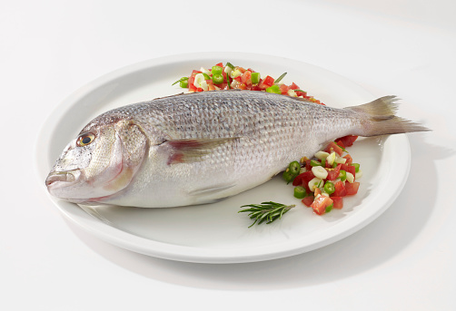 Sea bream fish in plate with garnish