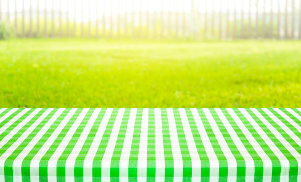 Table cloth with chopping board and blur green courtyard background.Summer and picnic concepts.Design for key visual food and drink products.no people