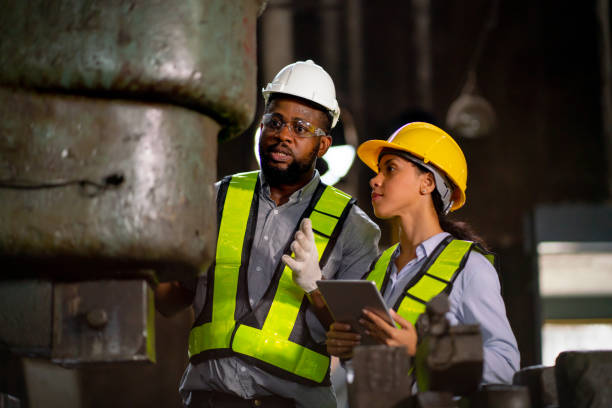 istock African American factory woman hold tablet and use to explain about machine function for her coworker and they also maintenance or repair process. 1437409379