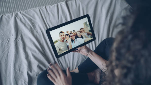istock Dark-haired girl is talking with friends online using tablet looking at display, gesturing and waving hand. Modern technology, chat with friends and millennials concept. 1437410138