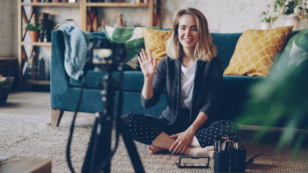 istock Make-up artist and blogger is recording video about face contouring using professional camera. Young woman is holding brush and cosmetics kit and speaking. 1437411045
