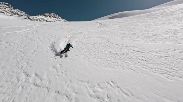 FPV sports drone shot male skier freeride downhill extreme speed movement winter mountain landscape