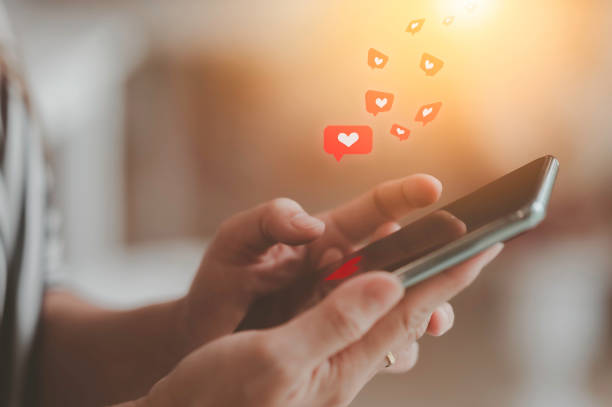 istock woman using mobile phone by hand heart shaped red 1437416697