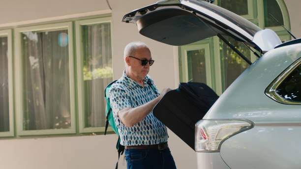 istock Daughter and grandparents loading voyage luggage inside car trunk 1437420587