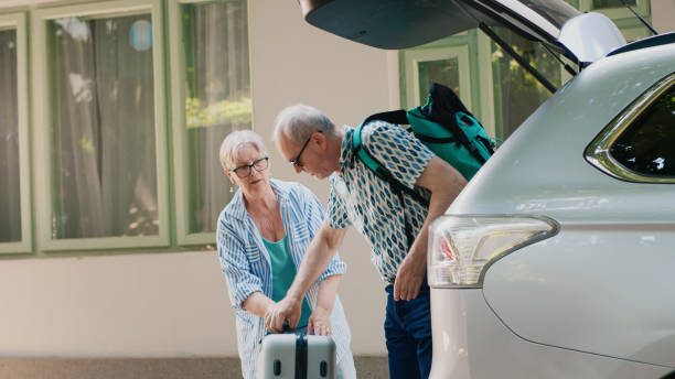 istock Elder people loading vehicle with baggage and trolleys 1437420726