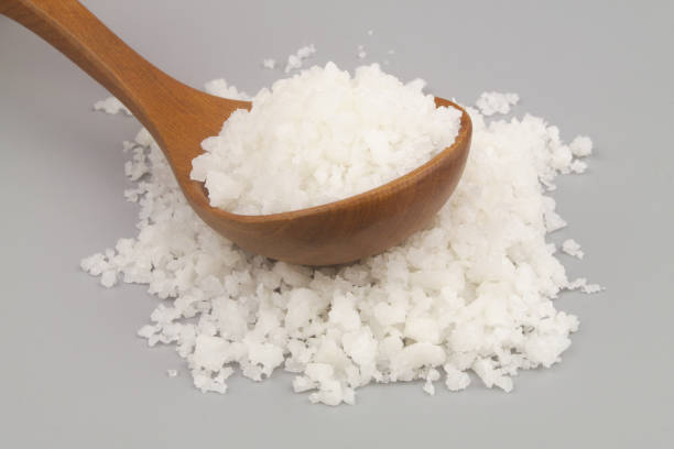 istock Salt in wooden spoon and on gray background 1437422896