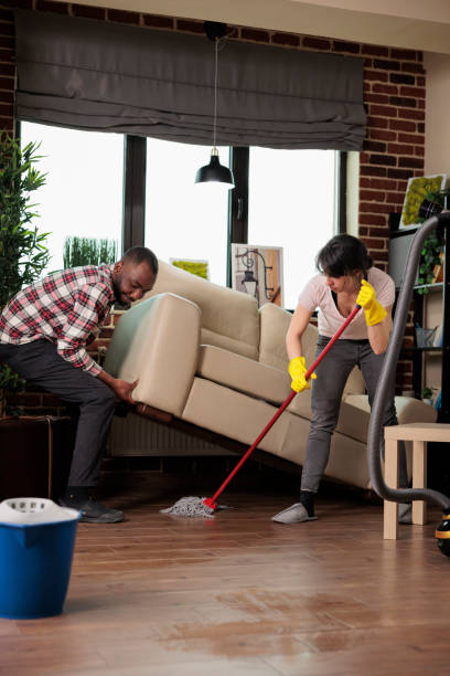 istock African american man lifts sofa while woman mops 1437423207