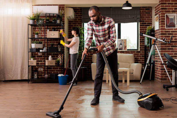 istock African american man vacuuming floor at home 1437424272