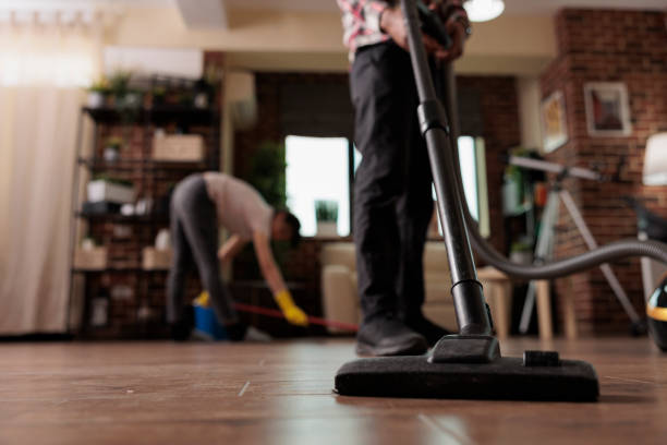 istock Man vacuuming floor while wife mops 1437425025