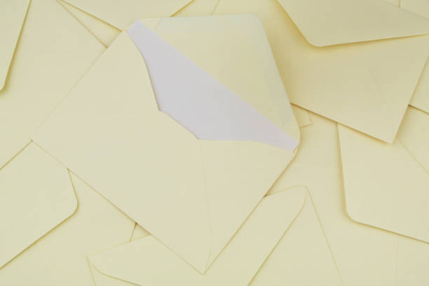 istock Many yellow mail envelopes close up. One envelope with letter. 1437425447