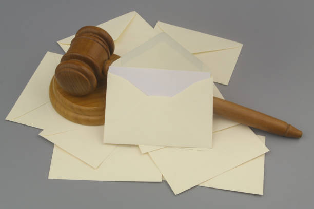 istock Mail envelopes and wooden judge gavel on gray background. 1437425511