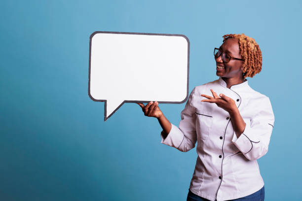 istock Female cook pointing to blank dialogue cloud 1437425532