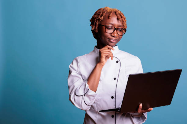 istock female chef with laptop looking up recipes for dishes 1437425603