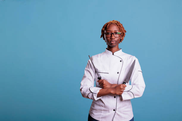 istock Chef holding knife and sharpener with arms crossed 1437426355