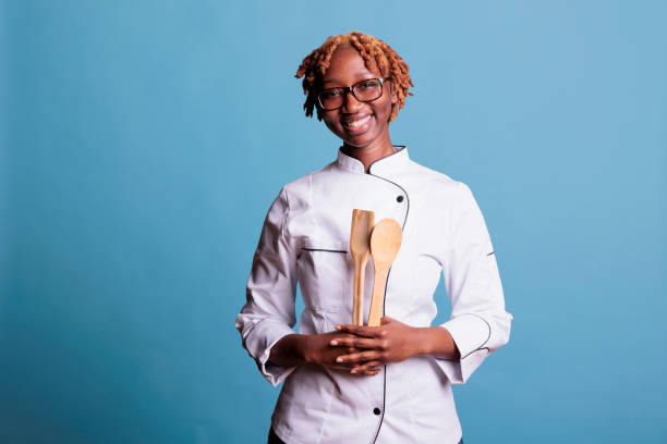 istock Female chef holding kitchen utensils in studio shot 1437427270