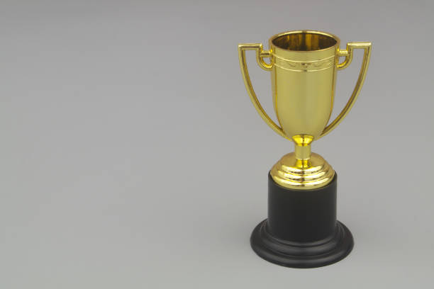 istock Gold trophy cup with copy space on gray background. 1437427371