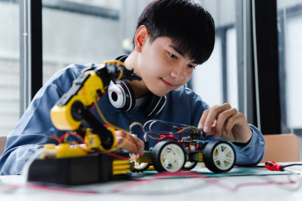 istock Asian teenager doing robot project in science classroom. 1437427486