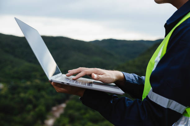 istock Young maintenance engineer man  working with laptop on the mountain. 1437427596