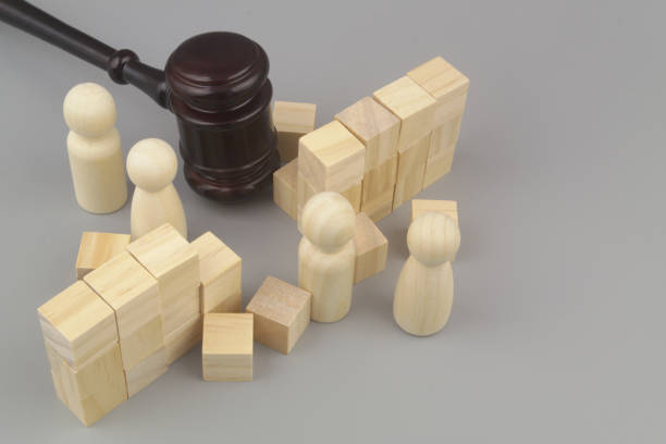 istock Wooden gavel breaking wall. and people figures on gray background. 1437430421