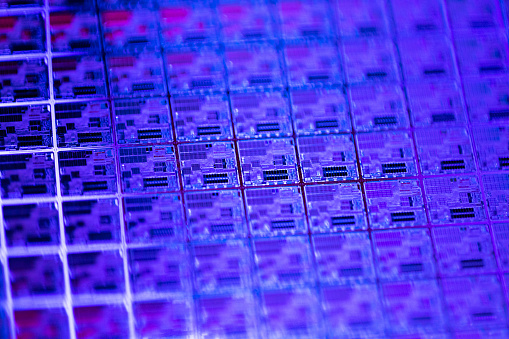 Macro of silicon wafer semiconductor with neon color - integrated circuits to manufacture CPU and GPU