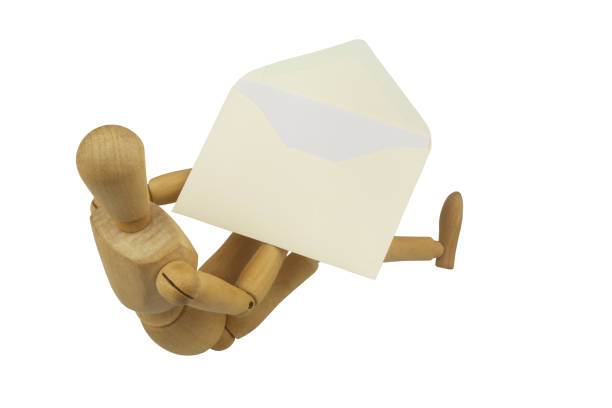 istock Wooden mannequin holding envelope with letter isolated on white background. 1437436288