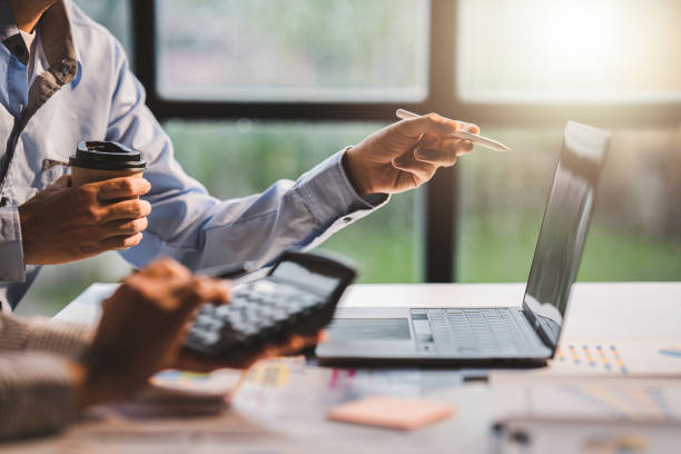 istock Young colleagues discuss business and analytical price charts using calculators and laptops to calculate financial, tax, accounting, statistics and analytical research ideas. 1437436291