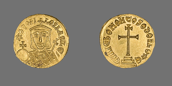 A top view of ancient gold coins isolated on gray surface background