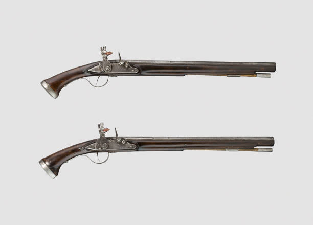 Pair of vintage pistols or muskets on a white bac A pair of vintage pistols or muskets on a white bac rifle old fashioned antique ancient stock pictures, royalty-free photos & images