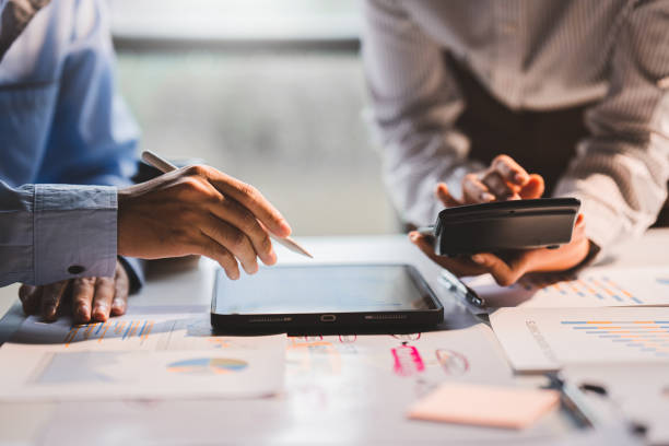 istock Young colleagues discuss business and analytical price charts using calculators and laptops to calculate financial, tax, accounting, statistics and analytical research ideas. 1437436730