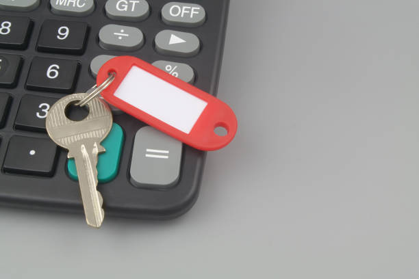istock Key with red label and calculator on gray background with copy space. 1437437311