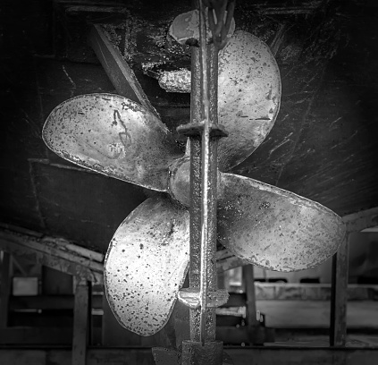 Old heavy ship's propeller (screw) of the rusty shipwreck vessel in the dry dock