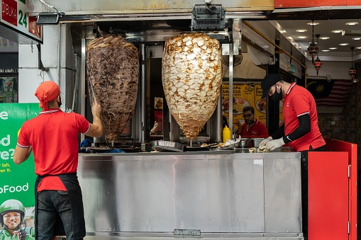 Kuala Lumpur, Malaysia - October 9,2022 : View of a chef preparing and making Traditional Turkish Doner Kebab meat. It also knowns as Shawarma.It is a one of the  famous street food in Bukit Bintang.