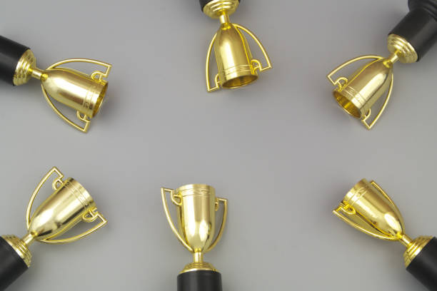 istock Gold champion trophy cups with copy space on gray background. 1437440460