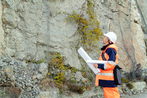 istock Mature male road construction engineer looking at blueprints 1437444755