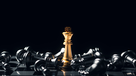 Close-up King standing on a chessboard. There's a falling chess in front, leadership. teamwork Business Team Challenges, Global Industry Winners.