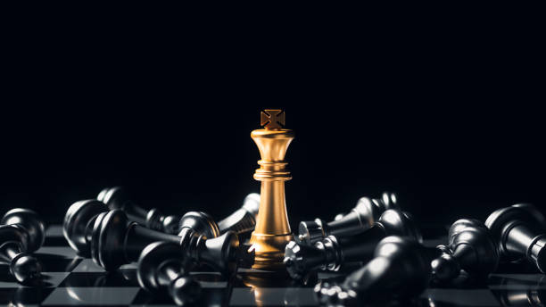 Close-up King standing on a chessboard. There's a falling chess in front, leadership. teamwork Business Team Challenges, Global Industry Winners. stock photo