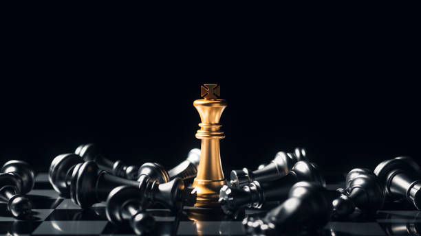 close-up king standing on a chessboard. there's a falling chess in front, leadership. teamwork business team challenges, global industry winners. - chess king chess chess piece black imagens e fotografias de stock