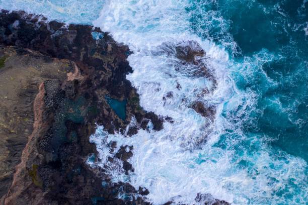 istock Aerial view of waves crashing on rocks 1437447272